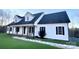 White farmhouse exterior with covered porch and landscaped lawn at 10962 Busbin Rd, Mount Pleasant, NC 28124