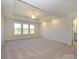 Large bedroom with tray ceiling, carpet, large windows for natural light, and ensuite bathroom access at 113 Quartz Hill Way, Waxhaw, NC 28173