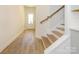 Bright hallway with light wood floors and a staircase leading to the upper level at 113 Quartz Hill Way, Waxhaw, NC 28173