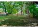 Large backyard with lush lawn and mature trees at 1135 12Th Ne St, Hickory, NC 28601