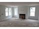 Open-concept living room with a fireplace and lots of natural light at 13605 Tranquil Day Dr, Matthews, NC 28105