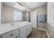 Bathroom with white vanity, large mirror, and light wood floor at 152 Eastcliff Se Dr, Concord, NC 28025