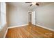 Bedroom with hardwood floors, ceiling fan, and access to another room at 2830 Royston Rd, Charlotte, NC 28208