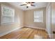 Spacious bedroom with hardwood floors, ceiling fan, and two windows at 2830 Royston Rd, Charlotte, NC 28208