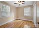 Spacious bedroom with hardwood floors, ceiling fan, and two windows at 2830 Royston Rd, Charlotte, NC 28208
