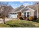 House exterior featuring a tan facade, white garage doors, and well-maintained landscaping at 3215 Osceola Ln, Charlotte, NC 28269