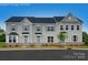 Three-unit townhome building, light taupe vinyl siding, dark gray roofs, and landscaping at 413 Serenity Cir, Cramerton, NC 28032