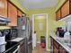 Galley kitchen with wood cabinets and laundry closet at 4408 Sharon Chase Dr # G, Charlotte, NC 28215