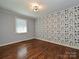 Charming bedroom with hardwood floors and nature-themed wallpaper at 718 Lochridge Rd, Charlotte, NC 28209