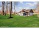 Landscaped backyard featuring a covered porch and nice lawn with trees in the background at 108 Robinson Dr, Cherryville, NC 28021