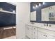 Modern bathroom with double sink vanity, white cabinets, dark hardware, and view into bedroom at 108 Robinson Dr, Cherryville, NC 28021