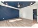Modern bedroom featuring a navy accent wall, tray ceiling, wood floors, recessed lighting, and natural light at 108 Robinson Dr, Cherryville, NC 28021