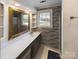 Bathroom with a gray vanity, brick feature wall, and hexagon tile floor at 117 Mardon Ln, Statesville, NC 28677