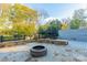 Large backyard with stone paver patio, stone seating, fire pit and a well maintained lawn with mature trees at 1333 Carlton Ave, Charlotte, NC 28203