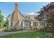 Charming two-story home with stone chimney, landscaped front yard, and inviting front porch at 1333 Carlton Ave, Charlotte, NC 28203
