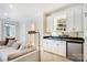 A bar with white cabinets and a mini fridge is featured in this living room at 1333 Carlton Ave, Charlotte, NC 28203
