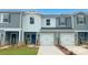 Charming townhouse featuring a gray and white exterior, single car garage and welcoming front door at 1608 Village Grove Ln, Monroe, NC 28110