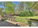 Expansive backyard featuring a wooden deck, lush greenery, and mature trees at 16415 Capps Rd, Charlotte, NC 28278
