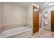 Bright bathroom featuring a soaking tub with tile surround and a shower, plus a vintage wallpaper at 16415 Capps Rd, Charlotte, NC 28278