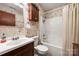 Cozy bathroom features floral wallpaper, tub-shower combination, and wood-look cabinets at 16415 Capps Rd, Charlotte, NC 28278