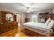 Spacious bedroom with hardwood floors, dresser, and a large bed frame with lots of drawers for storage at 16415 Capps Rd, Charlotte, NC 28278