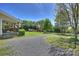 Gravel driveway leading to a well-maintained home with a covered porch and spacious front yard at 16415 Capps Rd, Charlotte, NC 28278