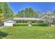 Charming ranch-style home featuring a welcoming front porch and lush green lawn at 16415 Capps Rd, Charlotte, NC 28278
