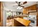 Kitchen with island, dining area, wood cabinets, hardwood floors, and natural light at 16415 Capps Rd, Charlotte, NC 28278