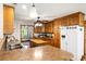 Well-lit kitchen featuring wood cabinets, countertop bar, and stainless steel appliances at 16415 Capps Rd, Charlotte, NC 28278