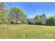 Expansive grassy field with scattered trees, showcasing the property's natural beauty at 16415 Capps Rd, Charlotte, NC 28278