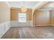 Spacious dining room with hardwood floors, wainscoting, and a stylish light fixture at 3043 Streamlet Way, Monroe, NC 28110