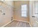 Laundry room with wire shelving, window with blinds and vinyl flooring at 3043 Streamlet Way, Monroe, NC 28110