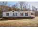 White single-wide mobile home with brick skirting and a covered porch at 461 Ret Stafford Ln, Taylorsville, NC 28681