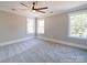 Well-lit bedroom with ceiling fan and grey carpeting at 604 Impala Dr, Albemarle, NC 28001