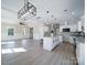 Open kitchen with white cabinets, granite island, and a farmhouse sink at 604 Impala Dr, Albemarle, NC 28001