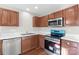 Modern kitchen with stainless steel appliances and wood cabinets at 6855 Juniper Tree St, Charlotte, NC 28215