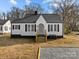 Charming white house with black accents, a gravel driveway and small front yard at 1004 N Salisbury Ave, Spencer, NC 28159