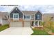 Two-story home with gray siding, stone accents, and a two-car garage at 193 Asmodean Ln, Troutman, NC 28166