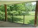 Covered balcony showcasing a black metal railing and a lovely outdoor view of the green lawn and trees at 1985 Lancer Ct, Gastonia, NC 28054