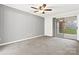 Spacious bedroom with plush carpet, ceiling fan, and sliding doors leading to a covered balcony at 1985 Lancer Ct, Gastonia, NC 28054