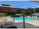 The community pool has many chairs for residents and is framed by green trees and a blue sky at 1985 Lancer Ct, Gastonia, NC 28054