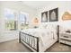 Bedroom with large windows, carpet flooring, and bed with metal frame at 212 Portrait Way, Indian Trail, NC 28079