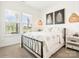 Bright bedroom with large windows, woven pendant light, and wrought iron bed frame at 212 Portrait Way, Indian Trail, NC 28079