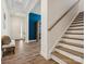 Bright entryway with wooden staircase and view into a room with blue wall at 212 Portrait Way, Indian Trail, NC 28079