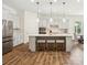 Bright kitchen featuring a large island with barstool seating and modern pendant lighting at 212 Portrait Way, Indian Trail, NC 28079