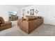 Spacious living room featuring a large leather sectional and entertainment center with a wall-mounted television at 212 Portrait Way, Indian Trail, NC 28079