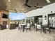 Covered outdoor patio with comfortable seating, a fireplace, ceiling fans, and easy access to indoor amenities at 212 Portrait Way, Indian Trail, NC 28079