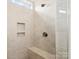 Shower room featuring a shower head, a shower bench and two built-in shelves at 212 Portrait Way, Indian Trail, NC 28079