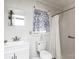 Cozy bathroom featuring a toilet, sink, shower, patterned curtain, and window at 2485 Nc Highway 109 S Hwy, Mount Gilead, NC 27306