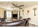 Comfortable living room with a plush leather sofa, large windows, and a ceiling fan for year-round comfort at 2485 Nc Highway 109 S Hwy, Mount Gilead, NC 27306